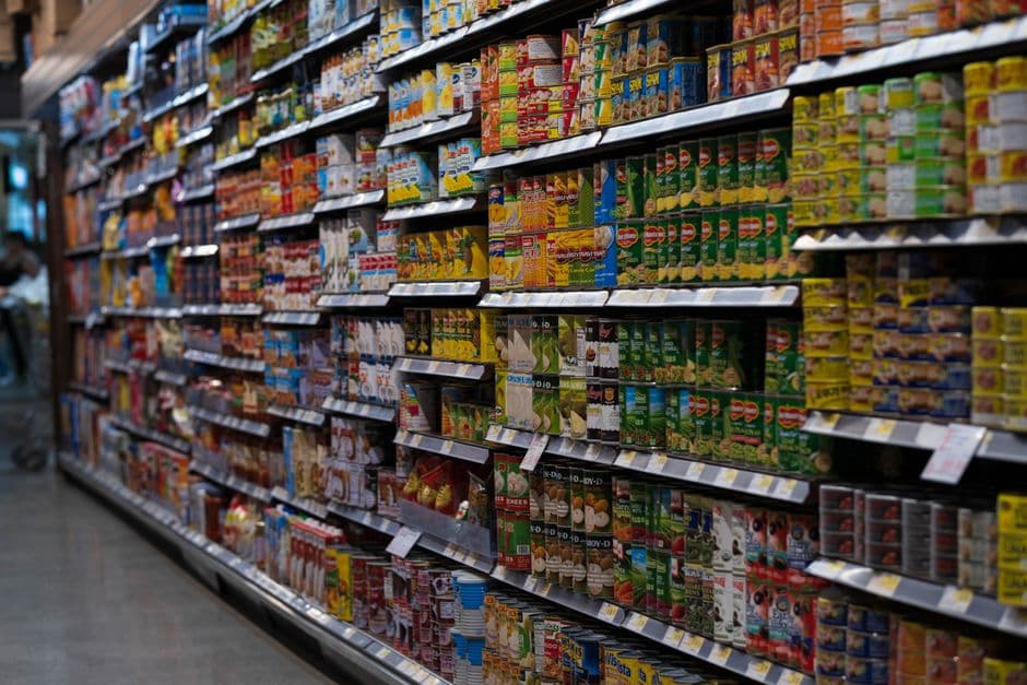 Grocery store aisle stocked with canned goods on shelves
