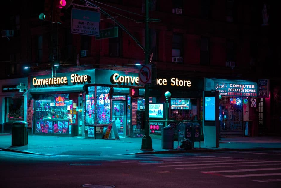 Neon-lit convenience store storefront in New York City at night